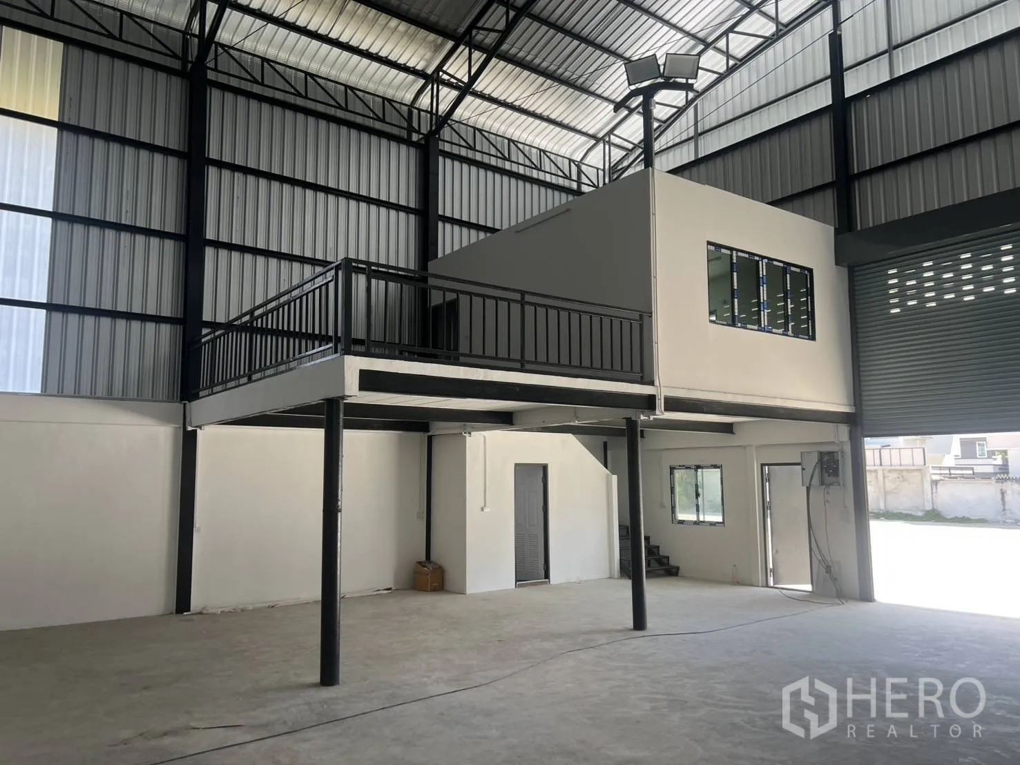 仓库 for rent in Bang Phli, Samut Prakan - 斜角拍摄的夹层平台与栏杆，上方办公室俯瞰仓库空地。