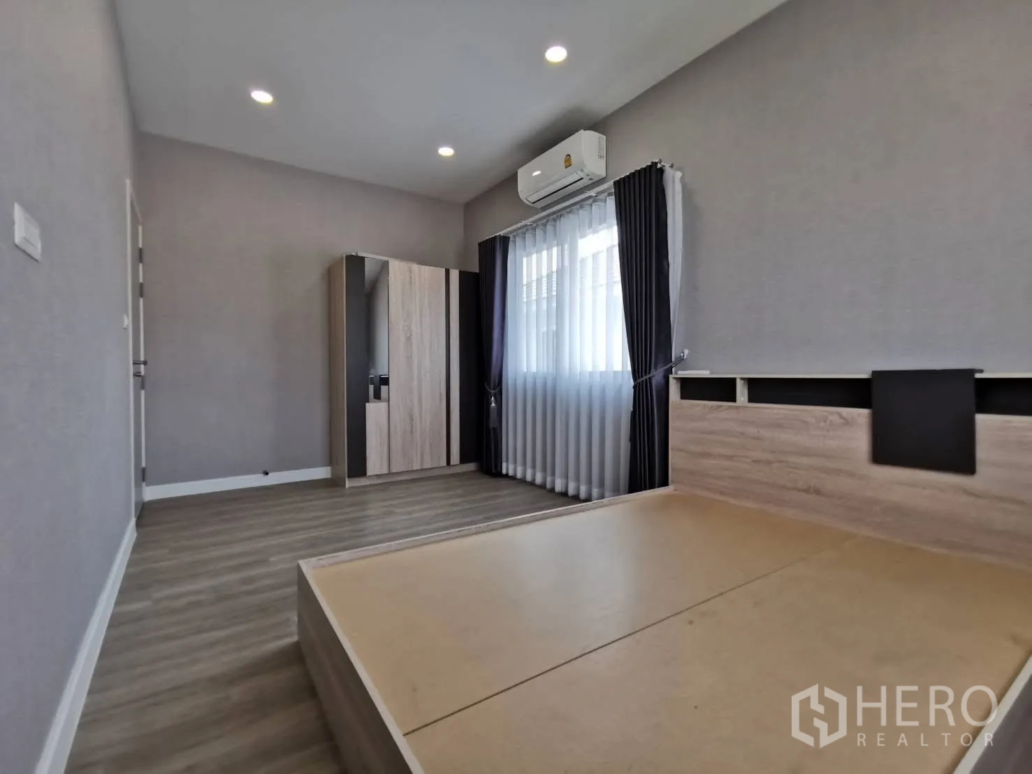 บ้านเดี่ยว for rent in Bang Phli, Samut Prakan - ห้องนอนมีตู้เสื้อผ้าบิวท์อิน ฐานเตียง ผนังโทนเทา พื้นไม้ และแอร์