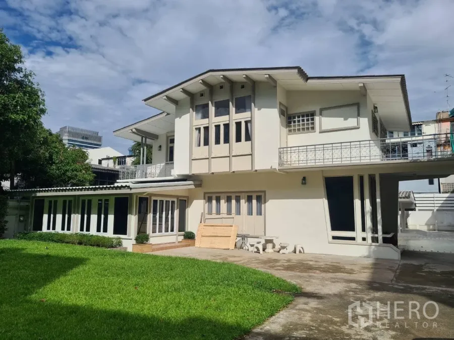 Detached House for rent in Khlong Toei, Bangkok - Two-storey detached house with wide lawn and balconies in Khlong Toei near Ekkamai BTS under a blue sky.