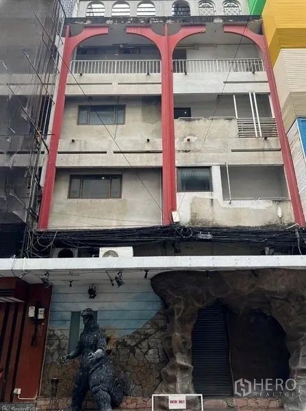 Shophouse for sale in Bang Rak, Bangkok - Street view of a multi-level shophouse exterior featuring red structural arches.