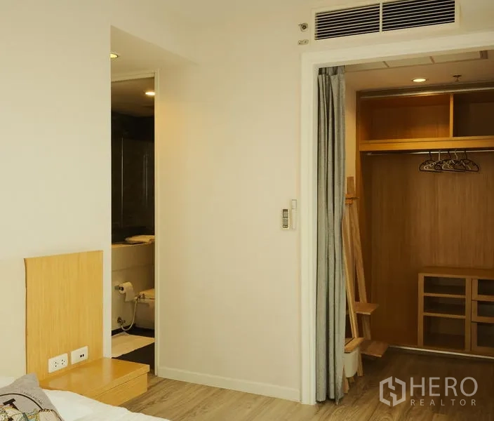 Condominium for rent in Bang Rak, Bangkok - Master bedroom view to bathroom entrance and walk-in closet.