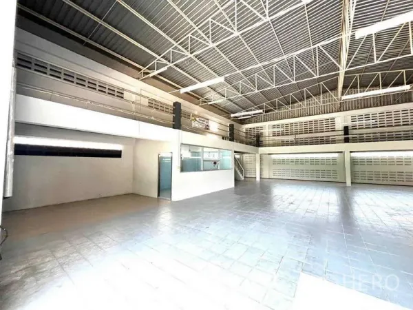 Warehouse for rent in Bang Phli, Samut Prakan - Spacious warehouse interior with high steel truss roof, tiled floors and mezzanine office.