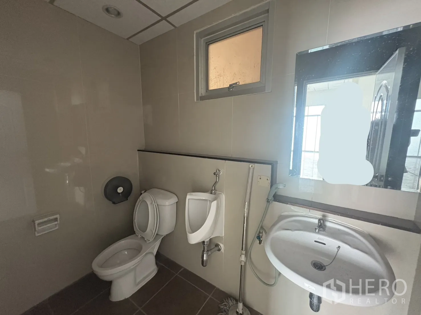 Factory for rent in Phra Samut Chedi, Samut Prakan - Restroom with toilet, urinal, sink and small window in a tiled finish.