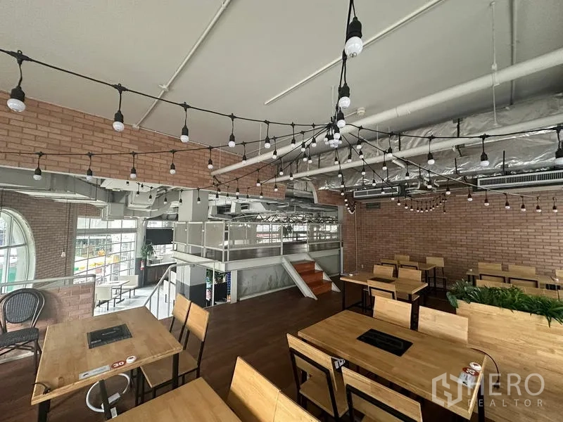Retail Space for rent in Watthana, Bangkok - Mezzanine seating area with festoon lights and exposed ducts.