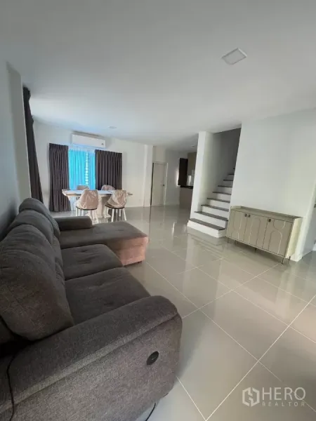 Detached House for rent in Bang Phli, Samut Prakan - Spacious lounge with glossy floor tiles and staircase beside the dining area.