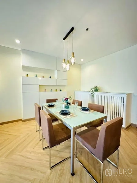 Condominium for rent in Bang Rak, Bangkok - Dining area set for six with modern pendant lights and built-in storage.