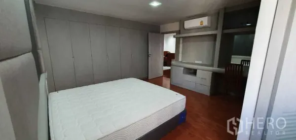 公寓 出租在Khlong Toei, Bangkok - 宽敞卧室，内置灰色衣柜与学习区。