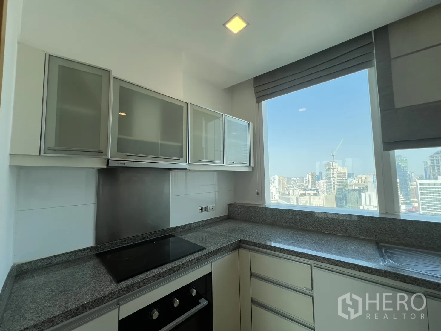 คอนโด for sale in Khlong Toei, Bangkok - ครัวบิลท์อิน เคาน์เตอร์หินแกรนิต เตาไฟฟ้า พร้อมหน้าต่างวิวเมือง