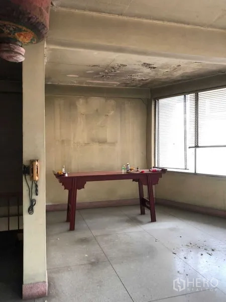 Shophouse for rent in Khlong Toei, Bangkok - Small corner space with aged ceiling and windows, suitable for storage or altar.