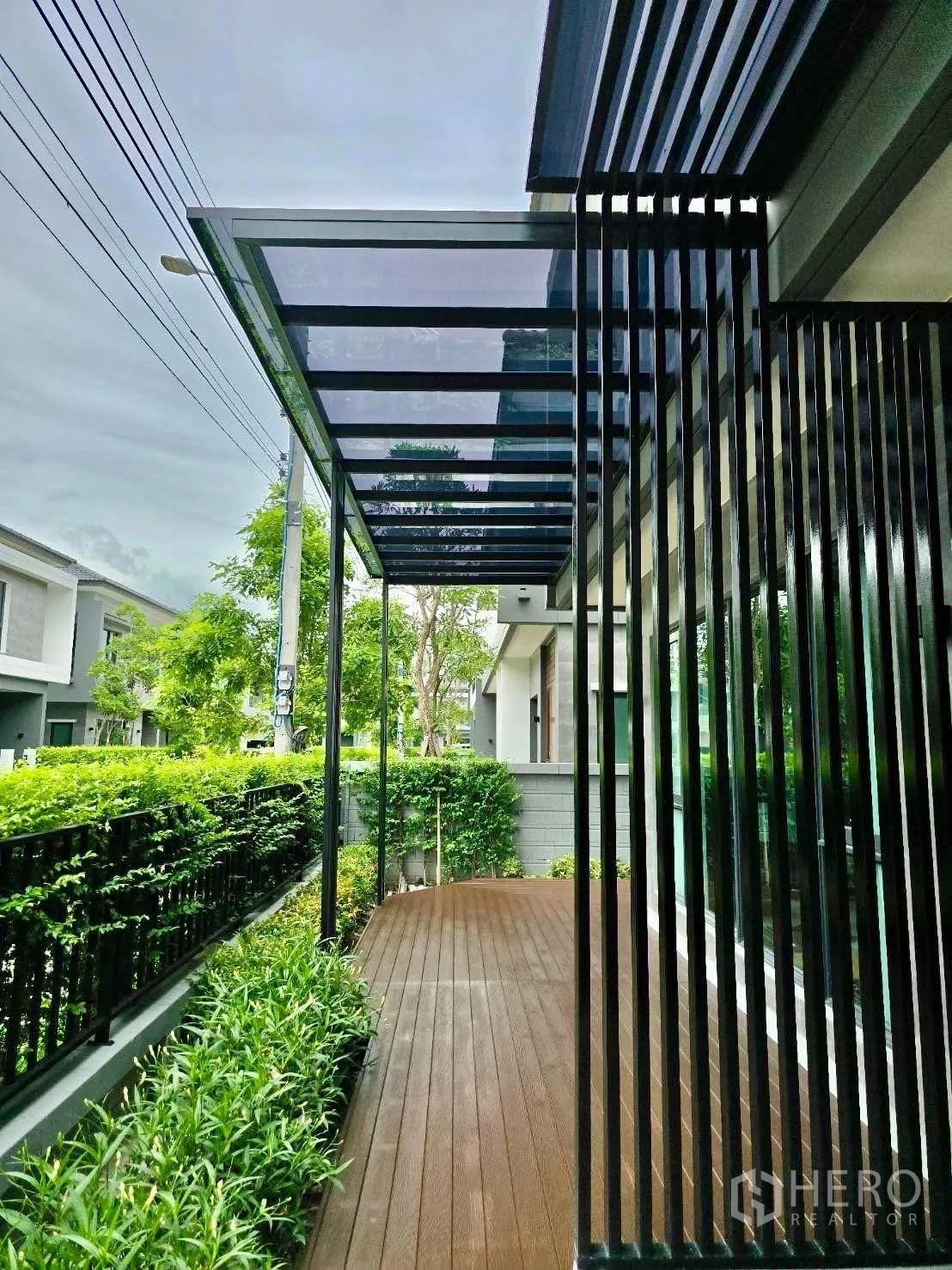 Detached House for rent in Bang Phli, Samut Prakan - Covered wooden deck beside landscaped hedges and a slatted screen.