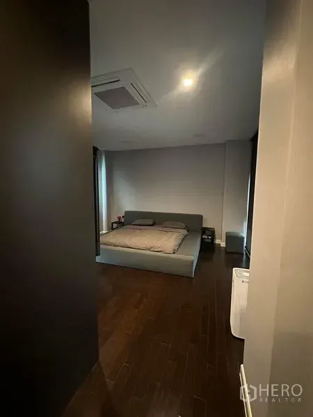 Detached House for rent in Saphan Sung, Bangkok - Cozy bedroom with dark wood flooring and low platform bed.