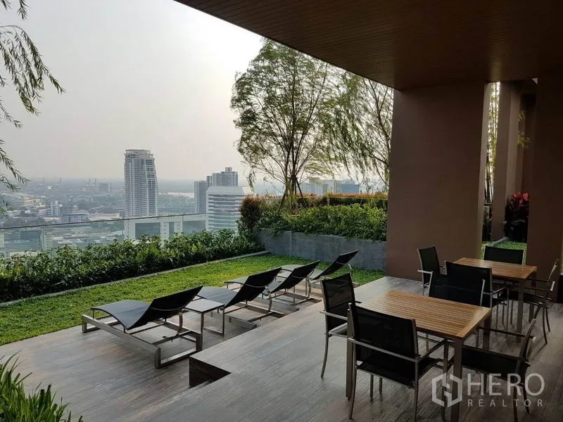 公寓 出租在Watthana, Bangkok - 屋顶花园露台配躺椅，眺望曼谷天际线。