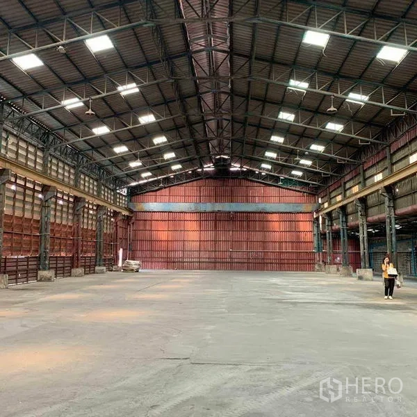 Warehouse for rent in Bang Kho Laem, Bangkok - Wide central aisle with clear‑span roof and expansive concrete flooring.