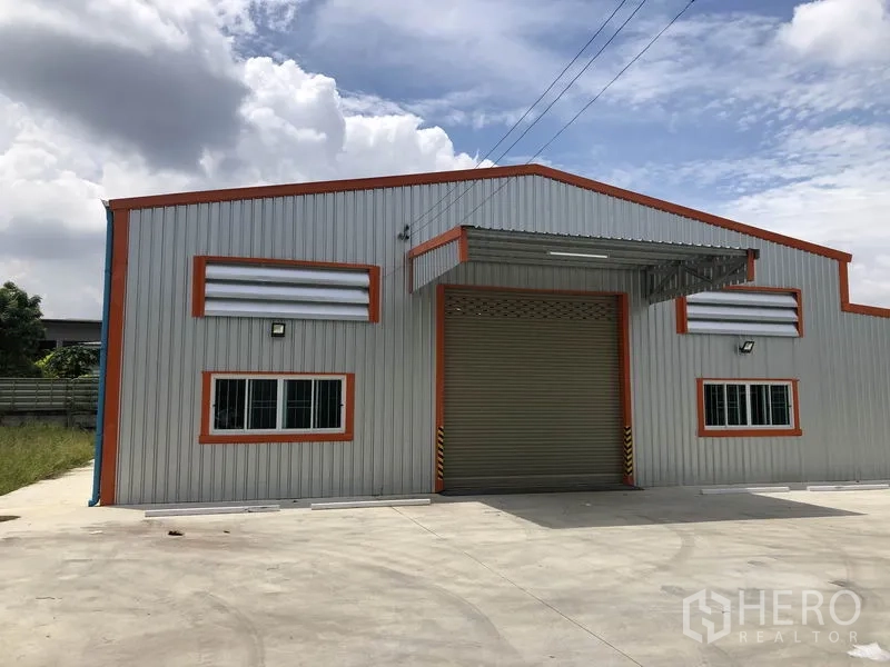 Warehouse for rent in Mueang Nonthaburi, Nonthaburi - Close-up of the warehouse facade showing the covered loading bay, large roll-up door and parking apron.