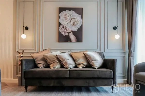 Condominium for rent in Khlong Luang, Pathum Thani - Elegant living room with velvet sofa, wall molding and framed floral artwork.
