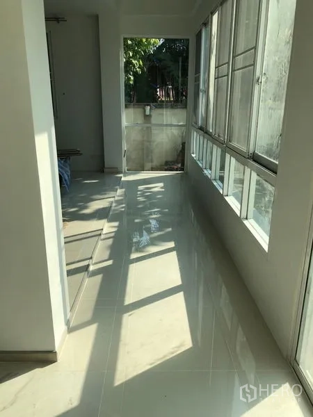 Detached House for rent - Sunlit enclosed corridor with floor-to-ceiling sliding windows and glossy tile flooring.