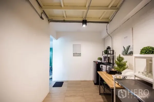 Home Office for rent in Phaya Thai, Bangkok - Compact pantry zone with open shelving, microwave and plants beneath an industrial ceiling.