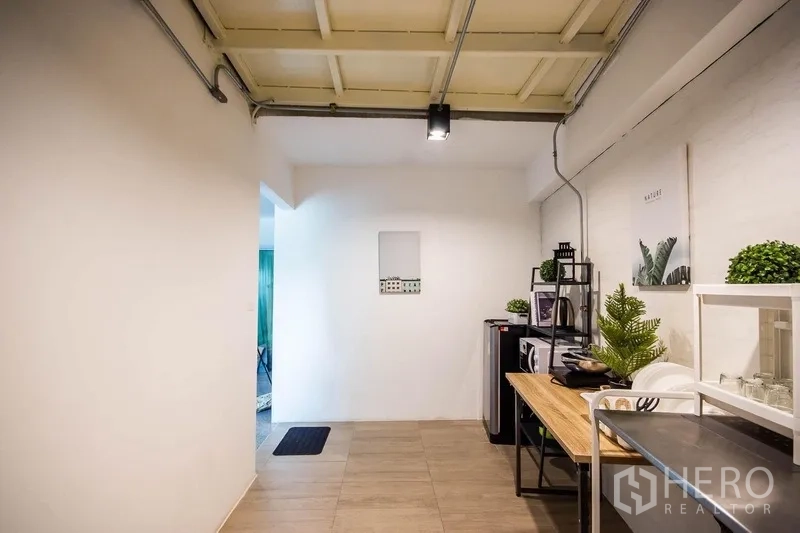 Home Office for rent in Phaya Thai, Bangkok - Compact pantry zone with open shelving, microwave and plants beneath an industrial ceiling.