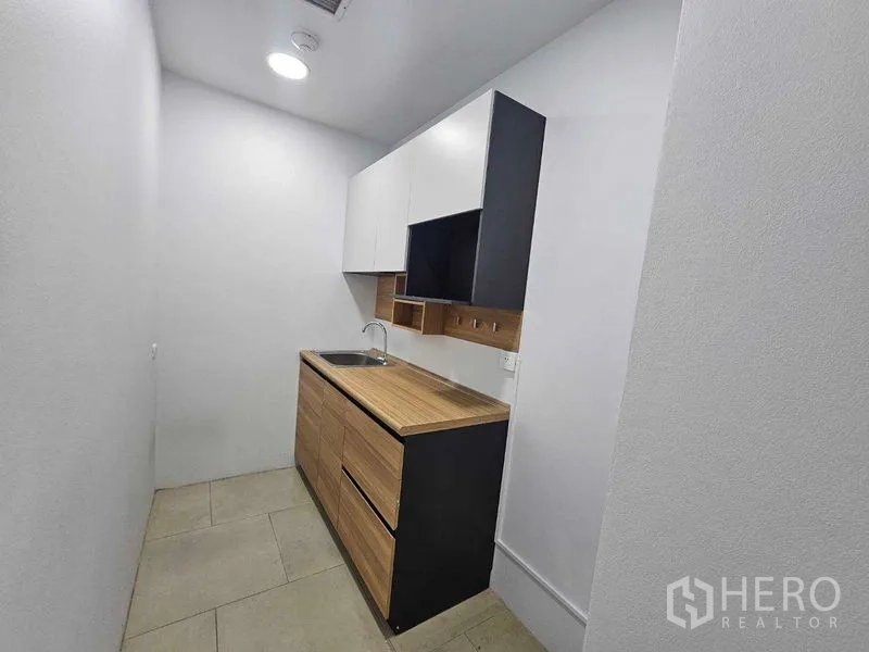Office Space for rent in Sathon, Bangkok - Compact office pantry with sink, cabinets and wood countertop.
