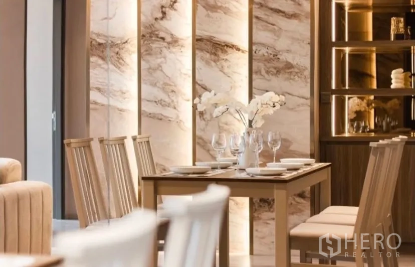 Condominium for rent in Watthana, Bangkok - Dining area with stone accent wall and lit display shelves.