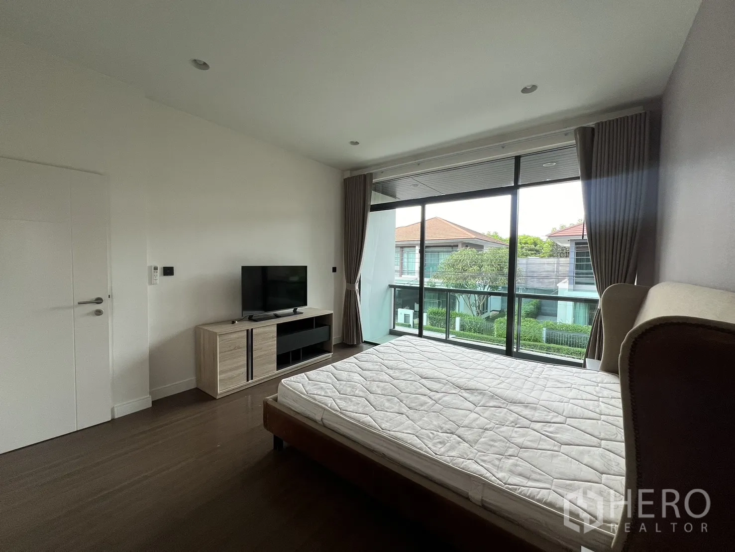 Detached House for rent in Bang Kapi, Bangkok - Wide angle of the master bedroom with bed and glass balcony doors.