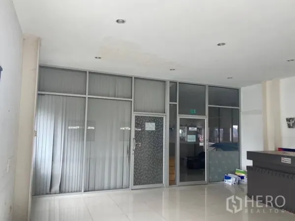 Factory for rent or sale in Lam Luk Ka, Pathum Thani - Ground-floor reception with glass-partitioned offices and glossy tiled flooring.