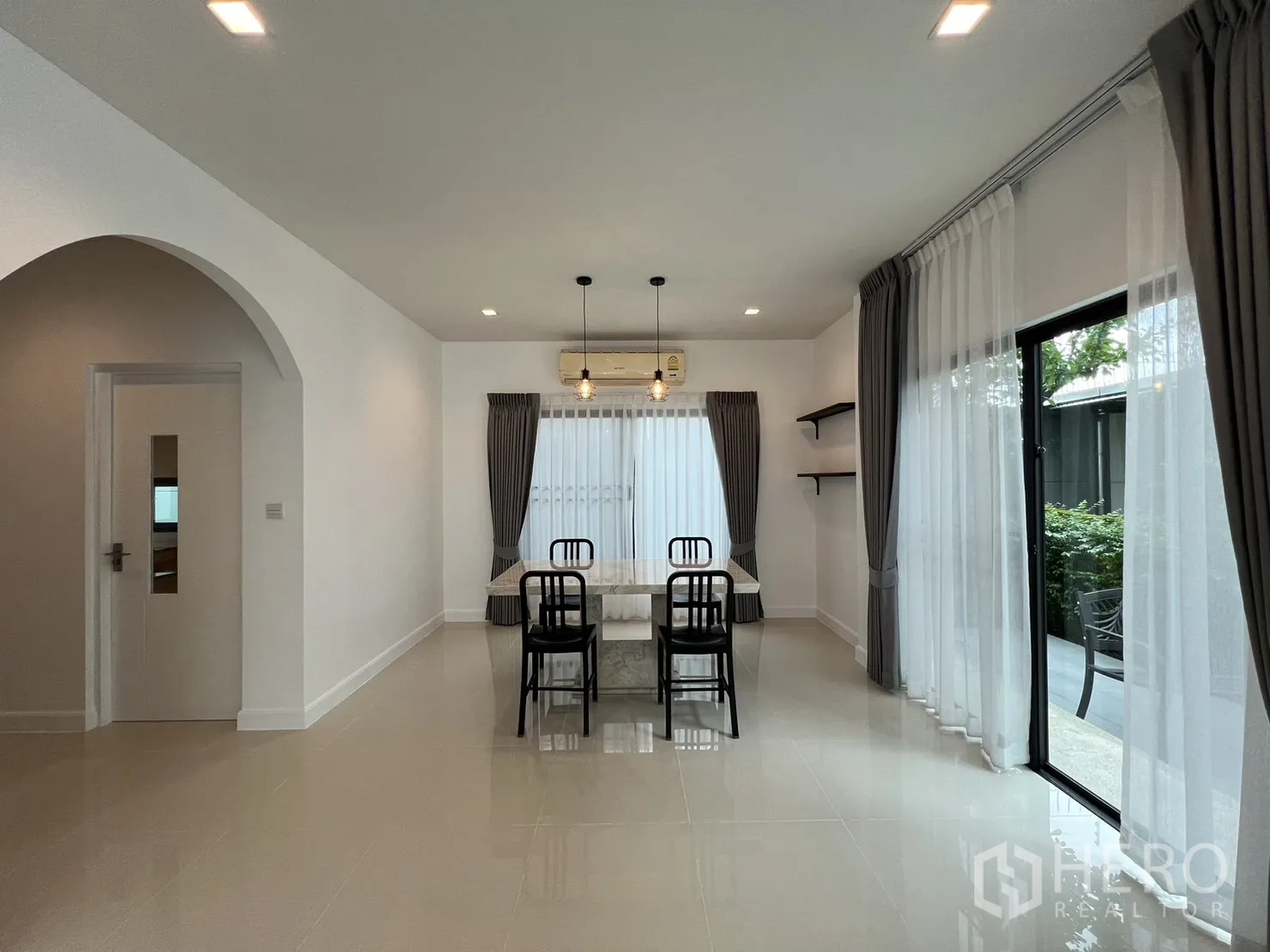 Detached House for rent in Bang Kapi, Bangkok - Dining area with marble table and chairs beside sliding door to the patio.