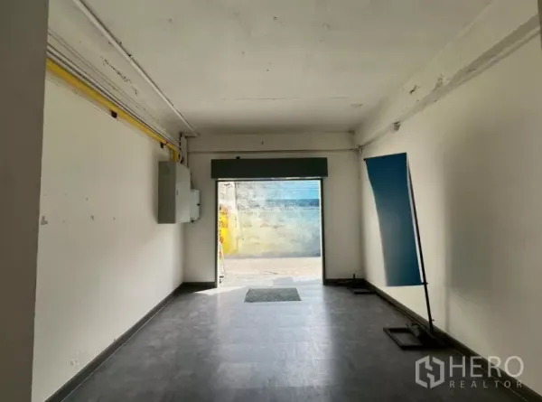 Retail Space for rent in Pathum Wan, Bangkok - Empty ground-floor retail unit with tiled floor, white walls, street-facing opening and utility boxes.