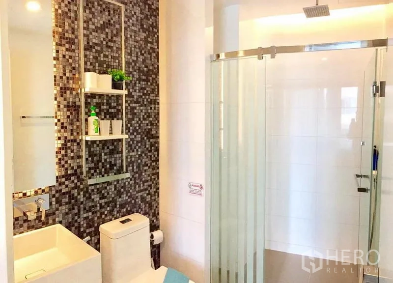 คอนโด ให้เช่าหรือขายในWatthana, Bangkok - ห้องน้ำสว่าง ผนังกระเบื้องโมเสก อ่างล้างหน้าทรงสี่เหลี่ยม และตู้กั้นอาบน้ำกระจกพร้อมเรนชาวเวอร์
