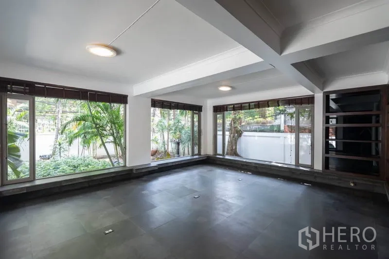 独立式住宅 出租在Pathum Wan, Bangkok - 日光房风格空间，落地窗围绕，景观为郁郁葱葱的花园。