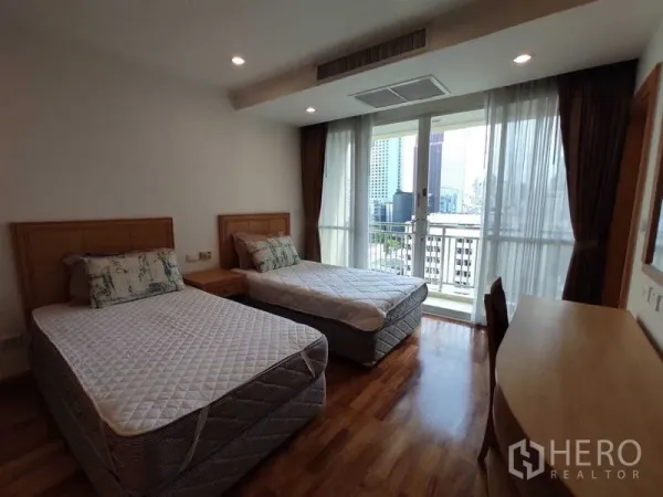 Condominium for rent in Khlong Toei, Bangkok - Bright bedroom with two single beds, wood floors and a balcony with city views through floor‑to‑ceiling windows.