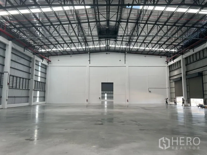 工厂 出租在Bang Pakong, Chachoengsao - 仓库内部开阔，抛光混凝土地面，高挑钢结构屋顶与天窗。