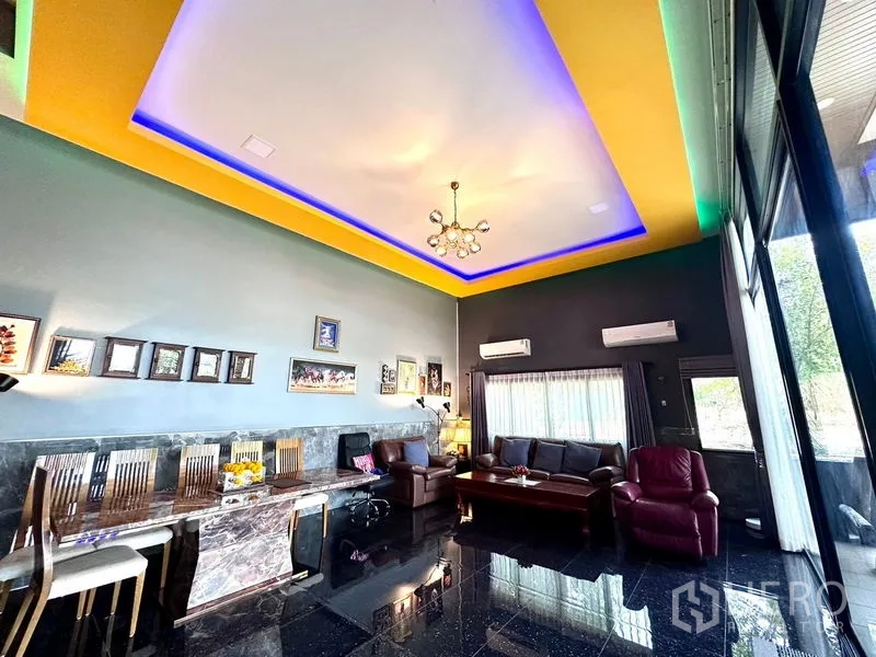 Detached House for sale in Bang Bua Thong, Nonthaburi - Wide lounge showcasing a glowing tray ceiling, leather sofas and large windows.