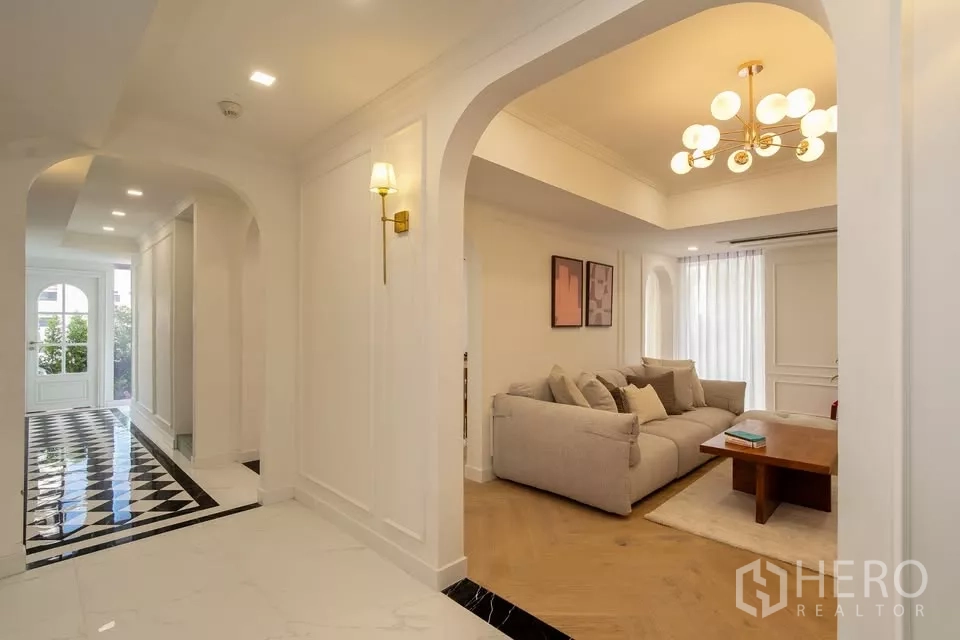 Condominium for sale in Watthana, Bangkok - Elegant Watthana condo hallway with arches, checkerboard floors and view into cozy lounge.