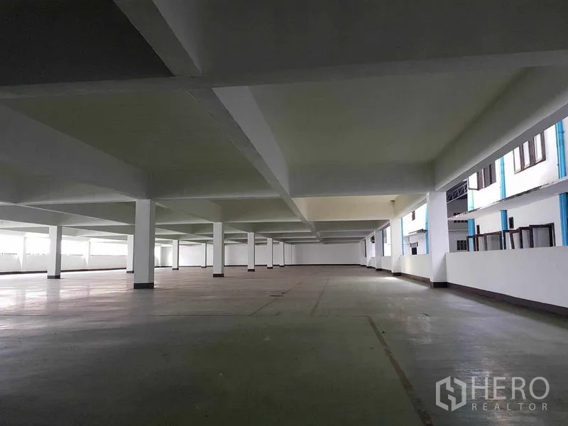 Warehouse for rent in Nong Khaem, Bangkok - Low-ceiling storage floor with white columns and exterior-facing windows.