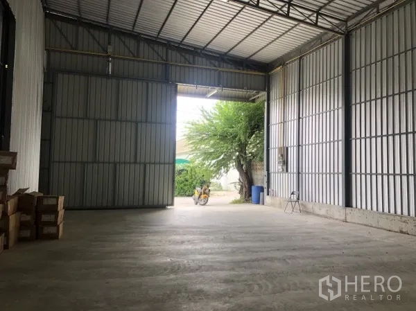 仓库 for rent in Wang Thonglang, Bangkok - 从仓库内部望向大型入口与平整混凝土地面。
