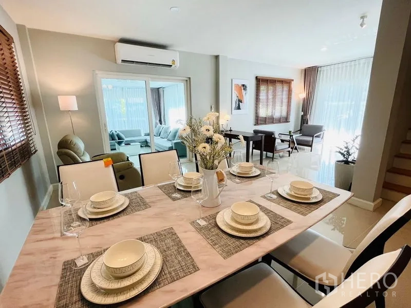 Detached House for sale in Lam Luk Ka, Pathum Thani - Dining area set for six with marble table, opening to the living rooms.