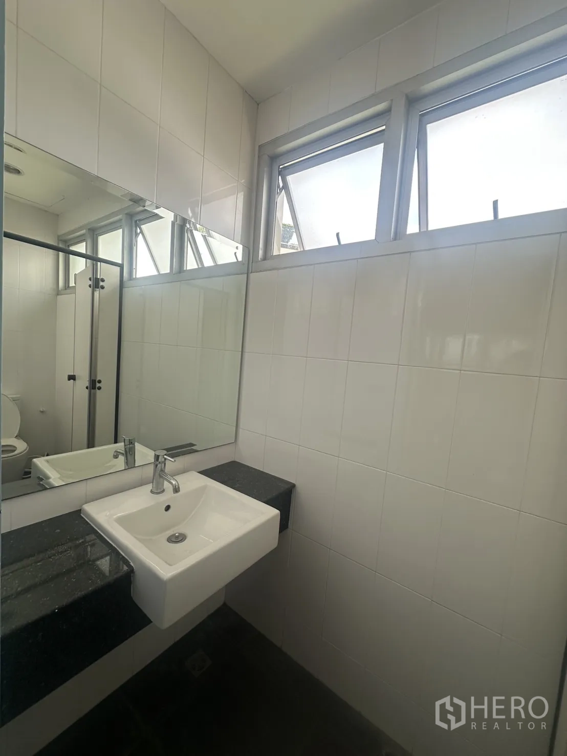 Retail Space for rent in Watthana, Bangkok - Vanity with basin, large mirror and ventilating windows in the restroom.