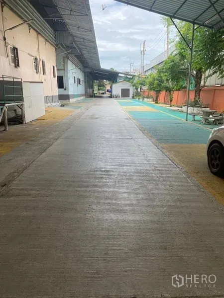 Warehouse for rent in Lam Luk Ka, Pathum Thani - Concrete access road and canopy leading to warehouse loading area
