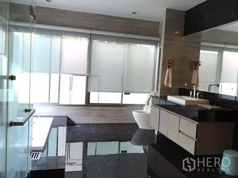 Detached House for sale in Saphan Sung, Bangkok - Spacious modern bathroom with glass shower, soaking tub and black marble flooring.