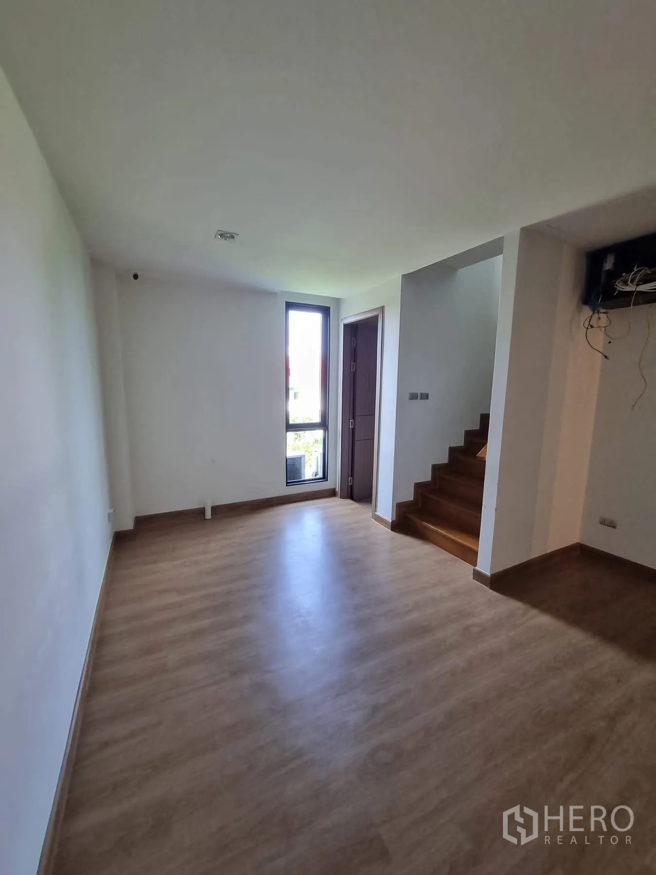 Home Office for rent in Khlong Toei, Bangkok - Upper living area with stairs and a tall window.