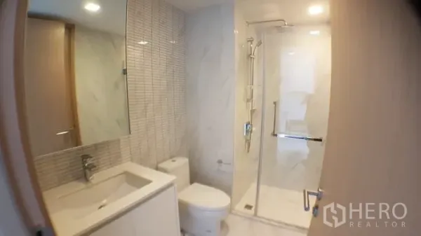 คอนโด ให้เช่าในWatthana, Bangkok - ห้องน้ำสไตล์โมเดิร์น พร้อมตู้กระจกอาบน้ำ กระจกบานใหญ่ และผนังหินอ่อนสีขาว ในคอนโดกรุงเทพฯ