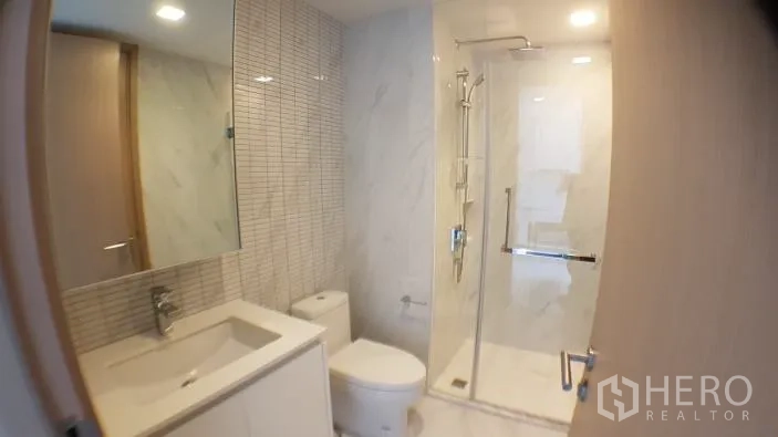 คอนโด ให้เช่าในWatthana, Bangkok - ห้องน้ำสไตล์โมเดิร์น พร้อมตู้กระจกอาบน้ำ กระจกบานใหญ่ และผนังหินอ่อนสีขาว ในคอนโดกรุงเทพฯ