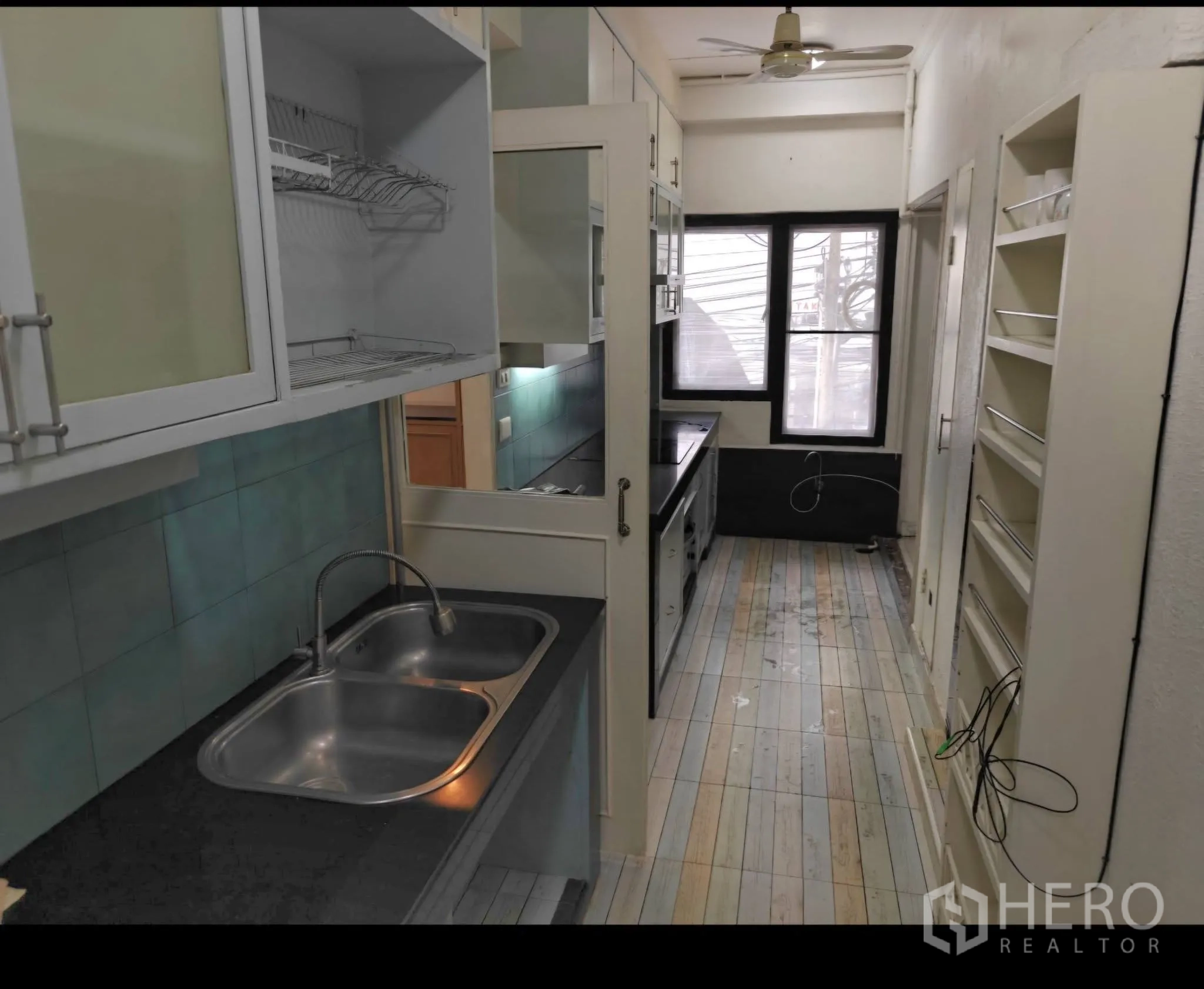 公寓 for rent in Sathon, Bangkok - 廊式厨房配双槽水槽、磨砂玻璃吊柜、开放搁架与采光窗。