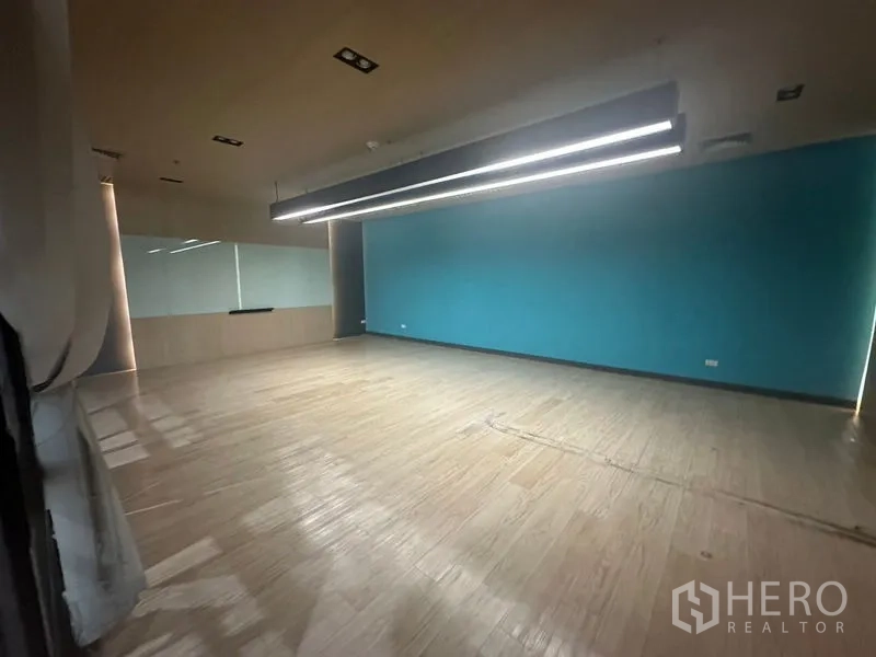 办公空间 出租在Bang Rak, Bangkok - 宽敞会议/培训室，青色主墙与线性灯带。