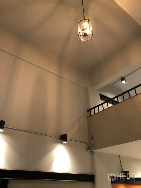 Retail Space for rent in Watthana, Bangkok - Double-height ceiling with a hanging pendant and mezzanine railing inside the shop.
