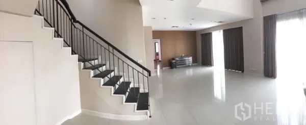 公寓 出租或出售在Pathum Wan, Bangkok - 宽敞的复式客厅，瓷砖地面、时尚楼梯与大落地窗帘。