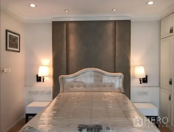 Condominium for rent or sale in Sathon, Bangkok - Master bedroom featuring upholstered headboard, twin wall sconces and soft neutral decor.