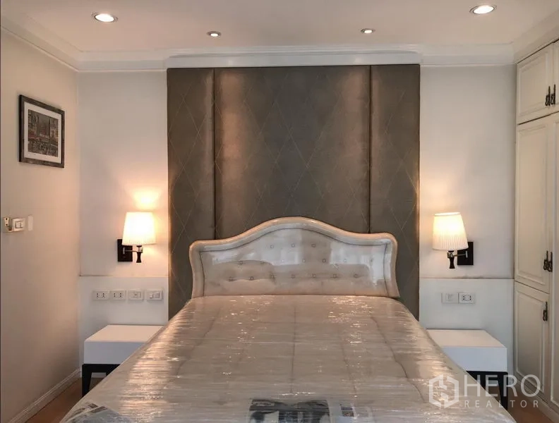 Condominium for rent or sale in Sathon, Bangkok - Master bedroom featuring upholstered headboard, twin wall sconces and soft neutral decor.