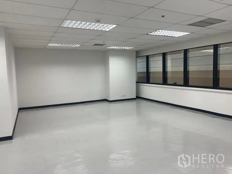 Office Space for rent in Watthana, Bangkok - Large open office with tiled flooring and a row of wide windows for natural light.
